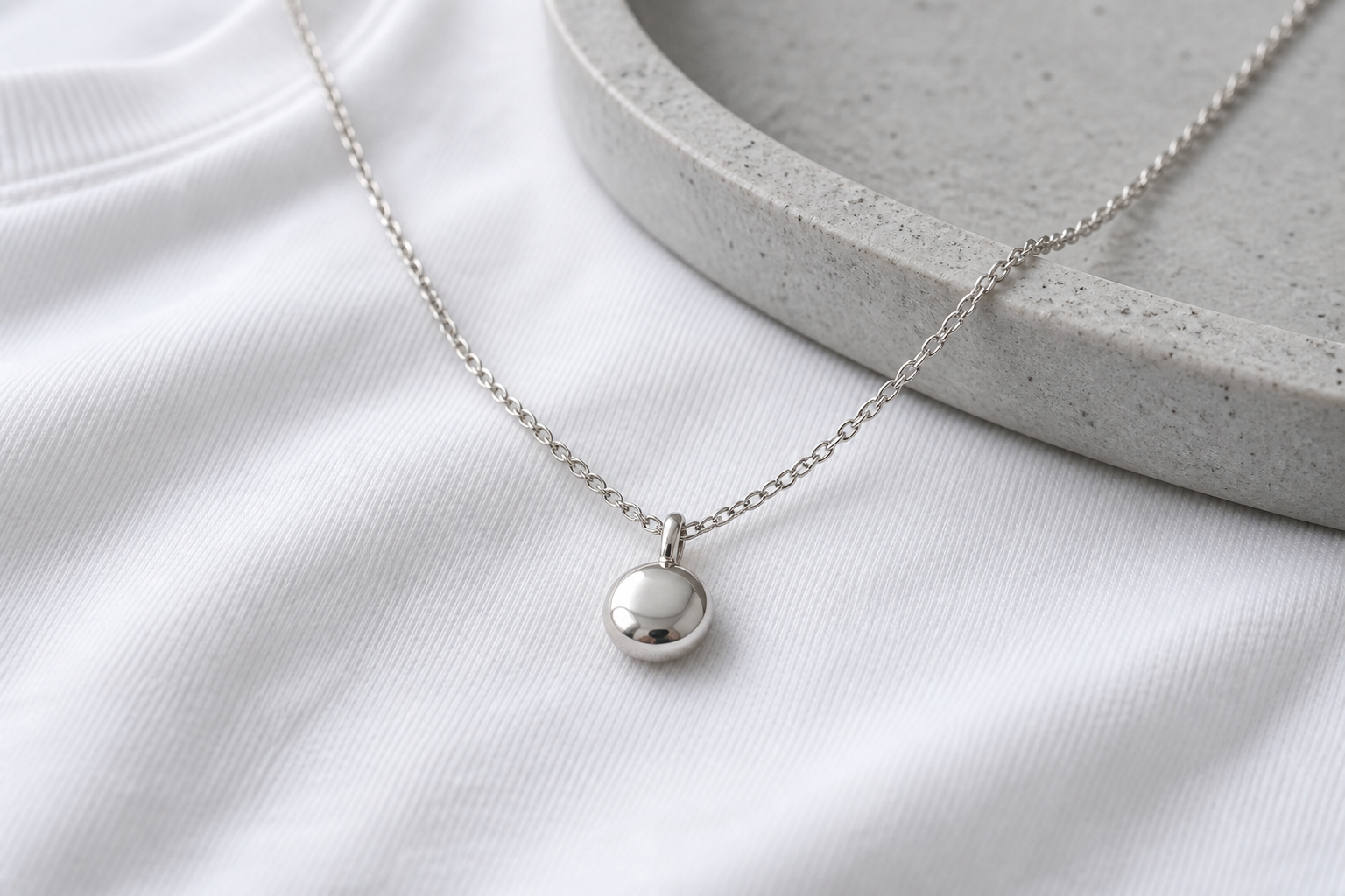 Silver tone smooth pendant necklace with soft studio light